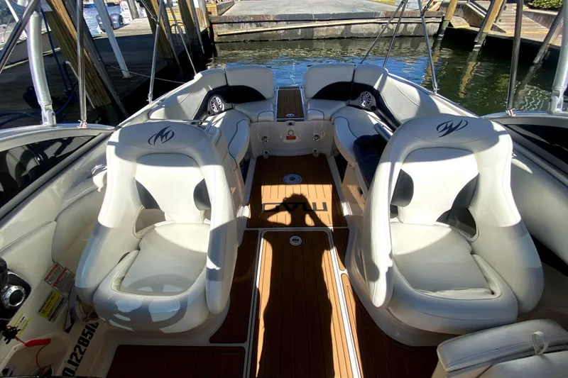 Slide: The Image of 2006 Monterey 263 Explorer Sport boat interior with white seating and wood flooring. - 31