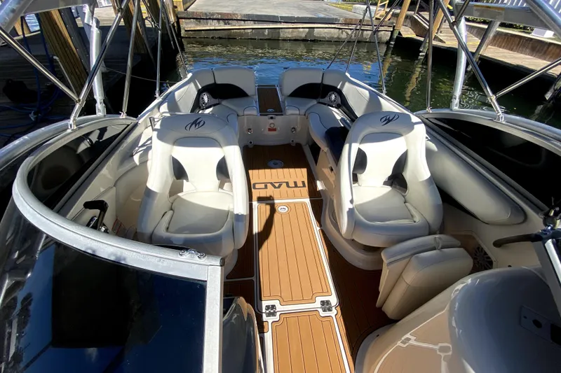 Slide: The Image of 2006 Monterey 263 Explorer Sport boat interior with white seating and wooden deck. - 32
