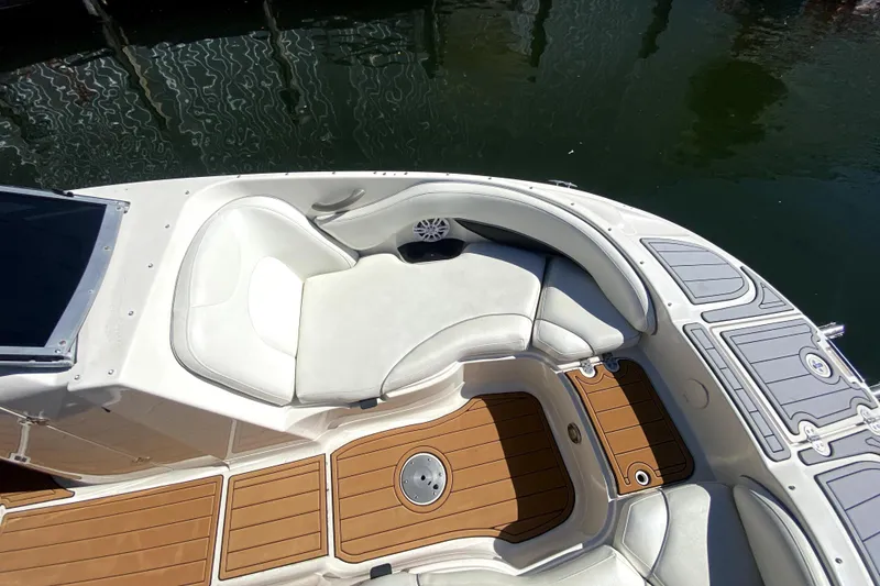 Slide: The Image of 2006 Monterey 263 Explorer Sport boat interior with white seating and wood-style flooring. - 35