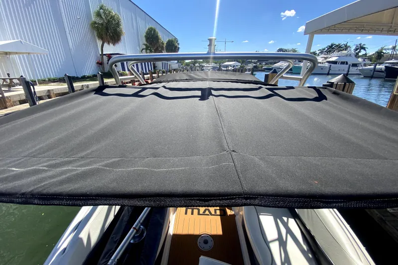 Slide: The Image of 2006 Monterey 263 Explorer Sport boat with black canopy docked at marina. - 39