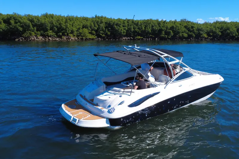 Slide: The Image of 2006 Monterey 263 Explorer Sport boat cruising on a sunny day, surrounded by lush greenery. - 7