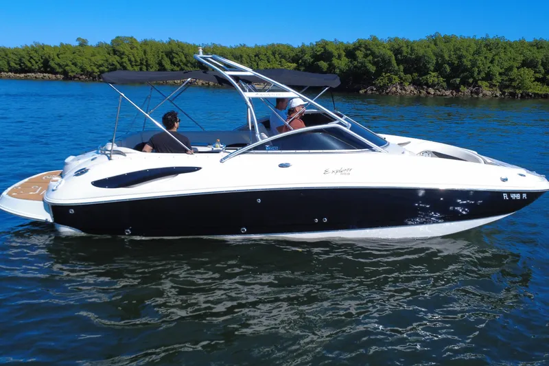 Slide: The Image of 2006 Monterey 263 Explorer Sport boat cruising on a sunny day with lush greenery in the background. - 8