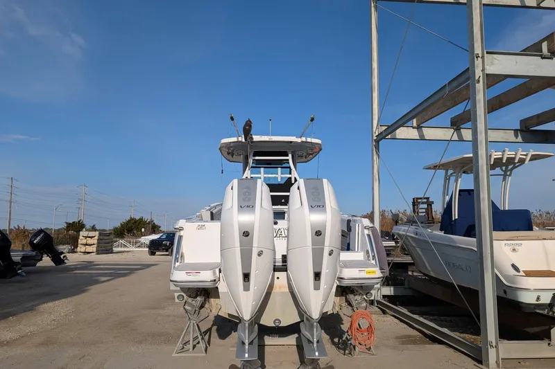 Slide: The Image of 2024 Blackfin 332 CC boat with dual outboard engines in a marina setting. - 1