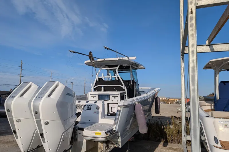 Slide: The Image of 2024 Blackfin 332 CC boat with dual Mercury engines, docked under clear blue sky. - 10