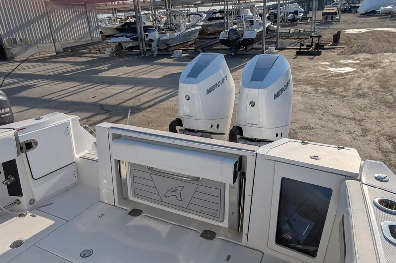 Slide: The Image of 2024 Blackfin 332 CC boat with dual Mercury Verado engines in a marina setting. - 17