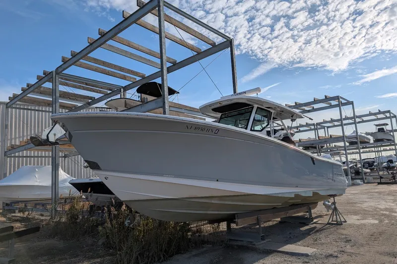 Slide: The Image of 2024 Blackfin 332 CC boat in storage, under a clear blue sky. - 3