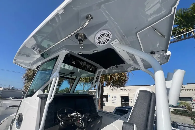 Slide: The Image of 2024 Blackfin 332 CC boat console with steering wheel and overhead speakers. - 33