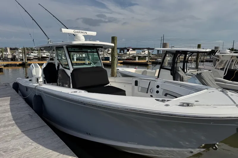 Slide: The Image of 2024 Blackfin 332 CC boat docked at marina, featuring Garmin equipment. - 4