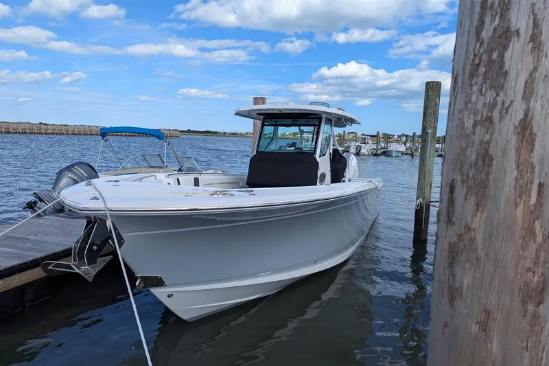 Slide: The Image of 2024 Blackfin 332 CC boat docked at marina under blue sky. - 6