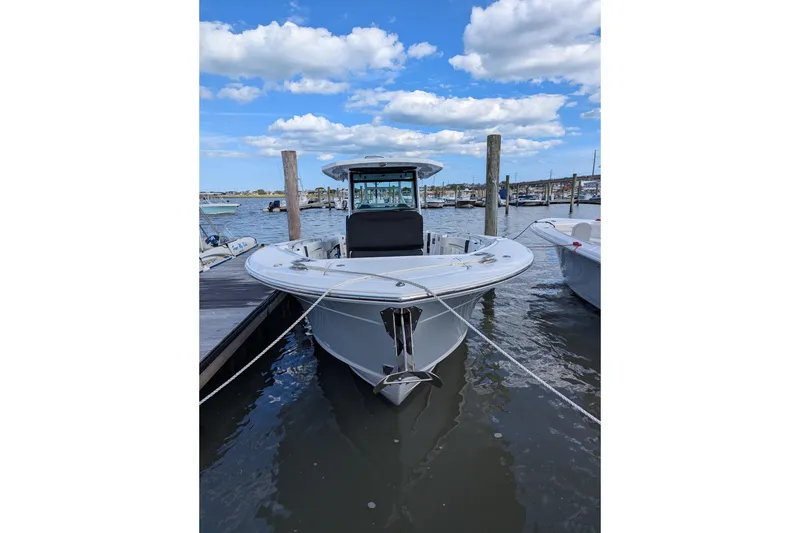 Slide: The Image of 2024 Blackfin 332 CC boat docked at marina under blue sky. - 7