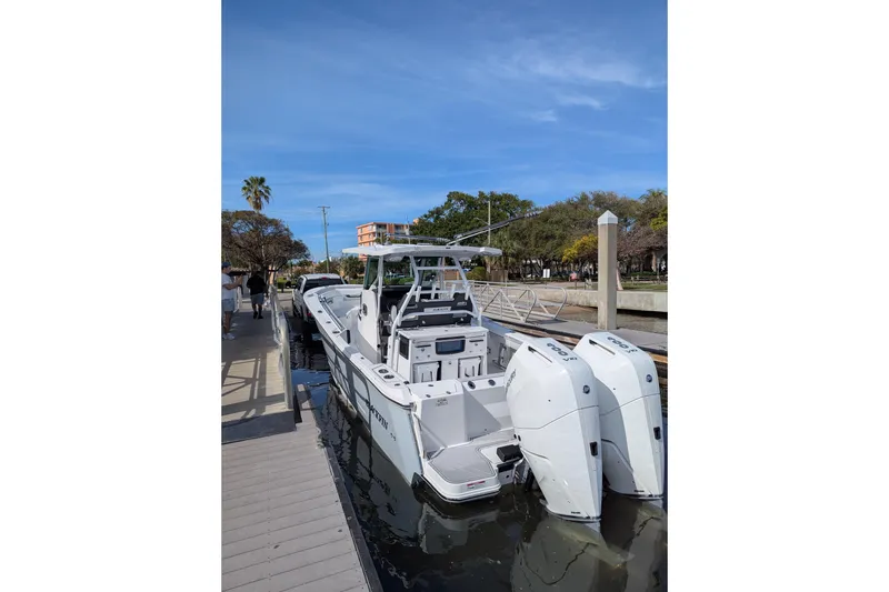 Slide: The Image of 2024 Blackfin 332 CC boat docked, featuring dual outboard engines and sleek design. - 8