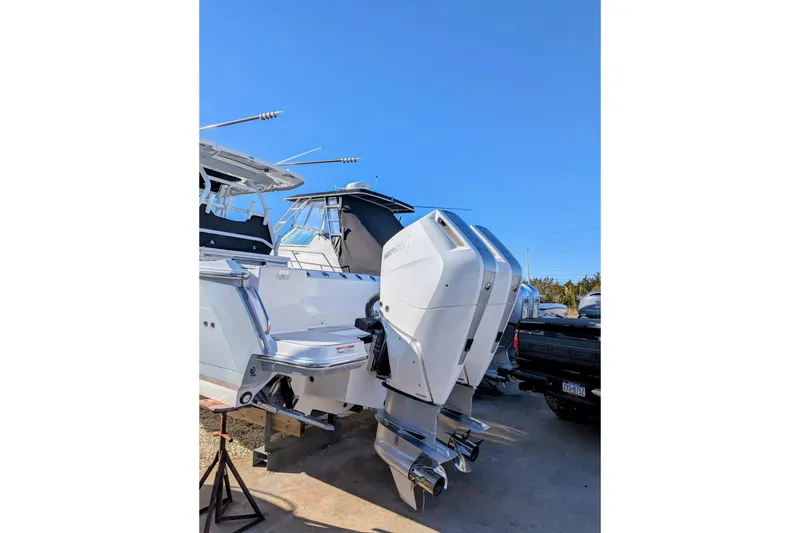 Slide: The Image of 2024 Blackfin 332 CC boat with dual outboard engines, docked under clear blue sky. - 9