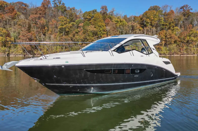 The Image of 2018 Sea Ray Sundancer 350 Coupe cruising on a calm lake with autumn foliage. - 0