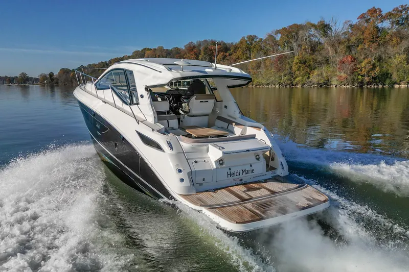 Slide: The Image of 2018 Sea Ray Sundancer 350 Coupe cruising on a serene lake with autumn foliage. - 11