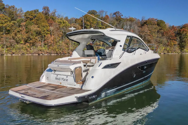 Slide: The Image of 2018 Sea Ray Sundancer 350 Coupe on calm water, surrounded by autumn trees. - 13