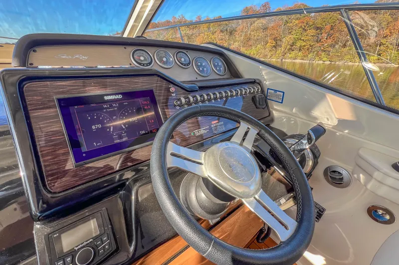 Slide: The Image of 2018 Sea Ray Sundancer 350 Coupe helm with modern navigation system and scenic lake view. - 15