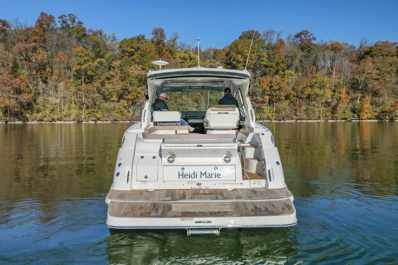 Slide: The Image of 2018 Sea Ray Sundancer 350 Coupe on serene lake with autumn foliage backdrop. - 2