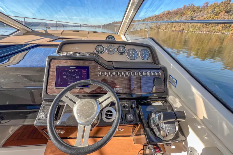 Slide: The Image of 2018 Sea Ray Sundancer 350 Coupe helm with modern controls and scenic water view. - 21