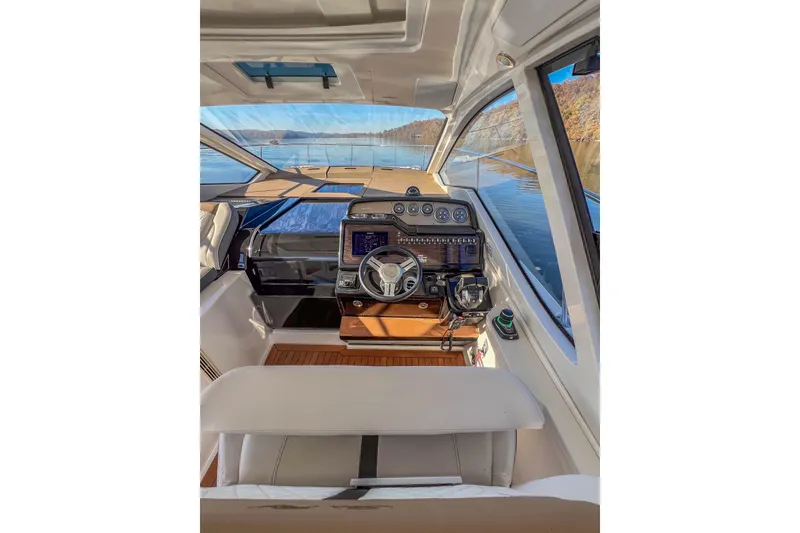 Slide: The Image of 2018 Sea Ray Sundancer 350 Coupe cockpit with modern controls and scenic water view. - 22