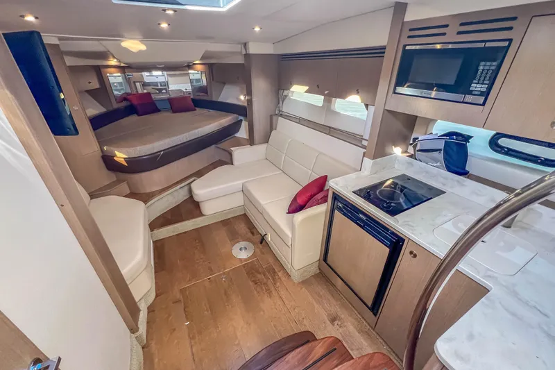 Slide: The Image of Interior of 2018 Sea Ray Sundancer 350 Coupe with modern kitchen and cozy seating area. - 27