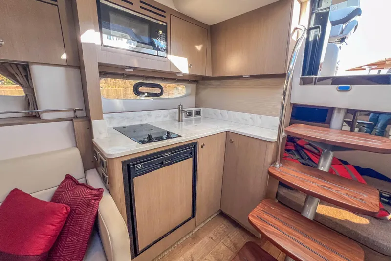 Slide: The Image of Interior of 2018 Sea Ray Sundancer 350 Coupe, featuring modern kitchen and wooden stairs. - 29
