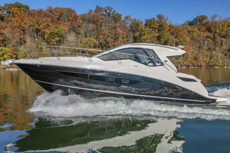 Slide: The Image of 2018 Sea Ray Sundancer 350 Coupe cruising on a scenic lake with autumn foliage. - 5