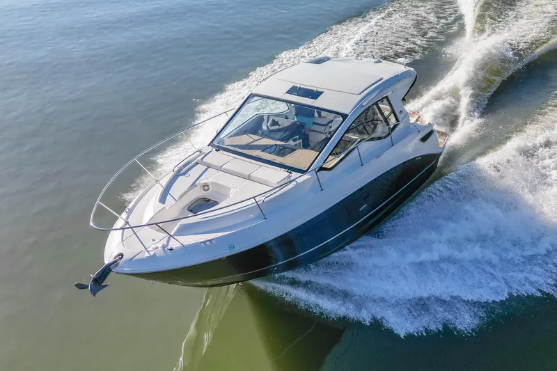 Slide: The Image of 2018 Sea Ray Sundancer 350 Coupe cruising on open water, creating a dynamic wake. - 6