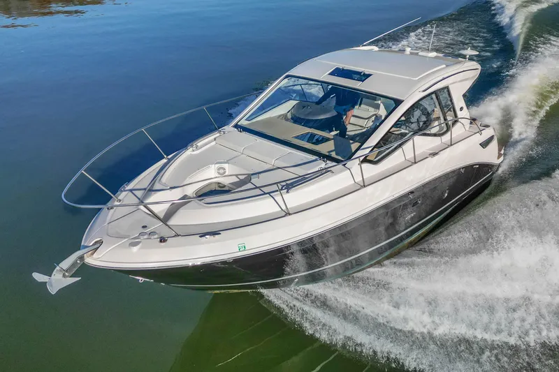 Slide: The Image of 2018 Sea Ray Sundancer 350 Coupe cruising on calm water, showcasing sleek design and performance. - 8