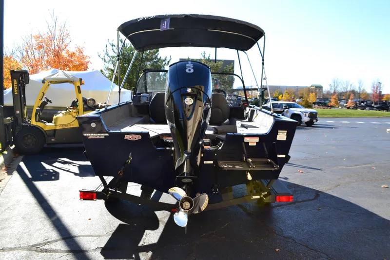 Slide: The Image of 2026 Tracker Pro Guide V-175 Combo boat with outboard motor in a parking lot. - 2