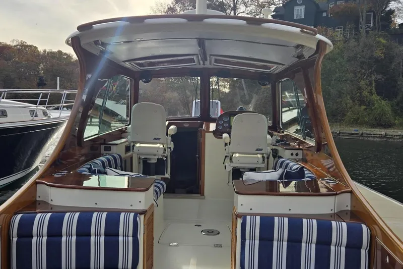 Slide: The Image of 2009 Hinckley 37 boat interior with striped seating and polished wood finish. - 14