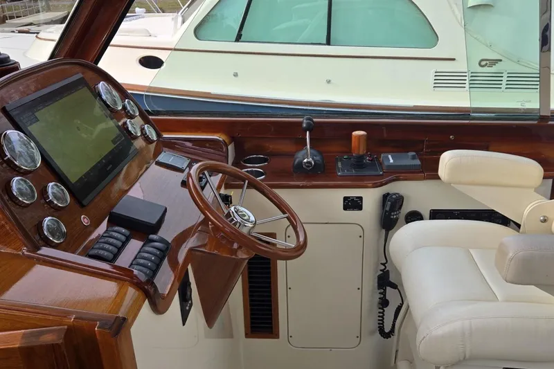 Slide: The Image of Helm of 2009 Hinckley 37 yacht with wooden dashboard and modern navigation controls. - 22
