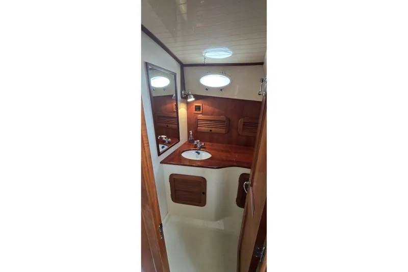 Slide: The Image of 2009 Hinckley 37 yacht bathroom with wooden cabinetry and round sink. - 27