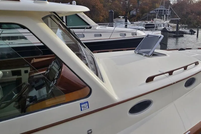 Slide: The Image of 2009 Hinckley 37 yacht docked, showcasing sleek design and elegant wood accents. - 11