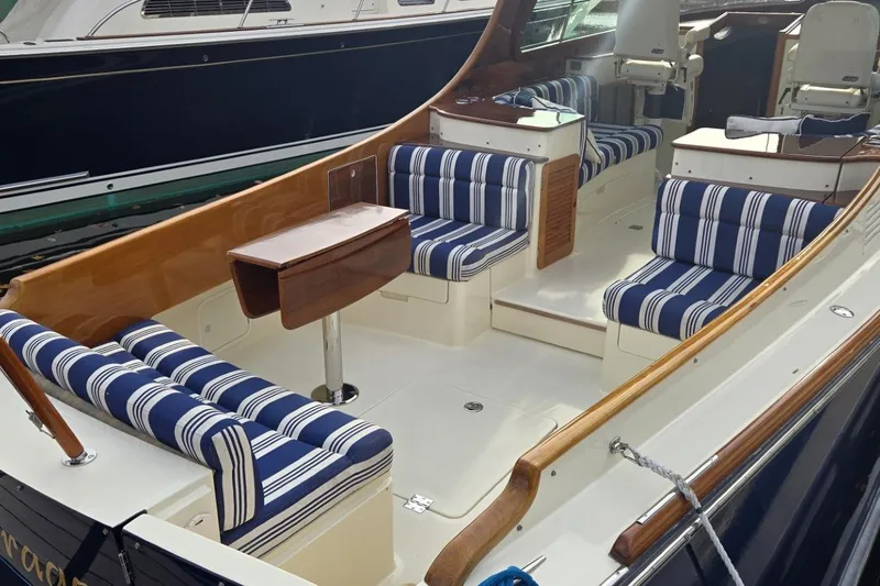 Slide: The Image of 2009 Hinckley 37 boat interior with striped seating and wooden accents. - 13