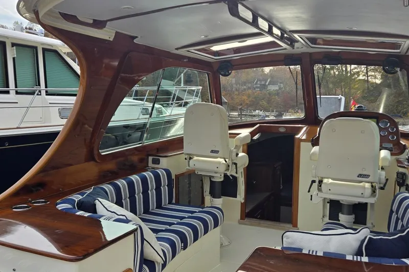Slide: The Image of Interior of a 2009 Hinckley 37 boat with striped seating and wooden accents. - 16