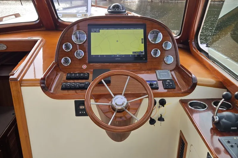 Slide: The Image of Helm of 2009 Hinckley 37 boat with wooden steering wheel and navigation display. - 19