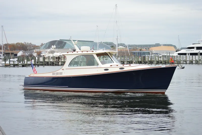 Slide: The Image of 2009 Hinckley 37 boat docked in a marina, featuring a sleek navy hull. - 2