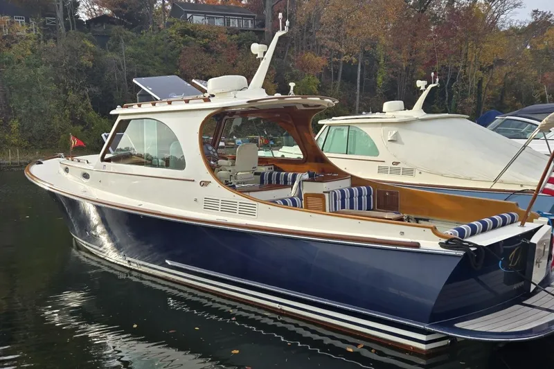 Slide: The Image of 2009 Hinckley 37 yacht with blue hull, docked in a serene marina setting. - 7