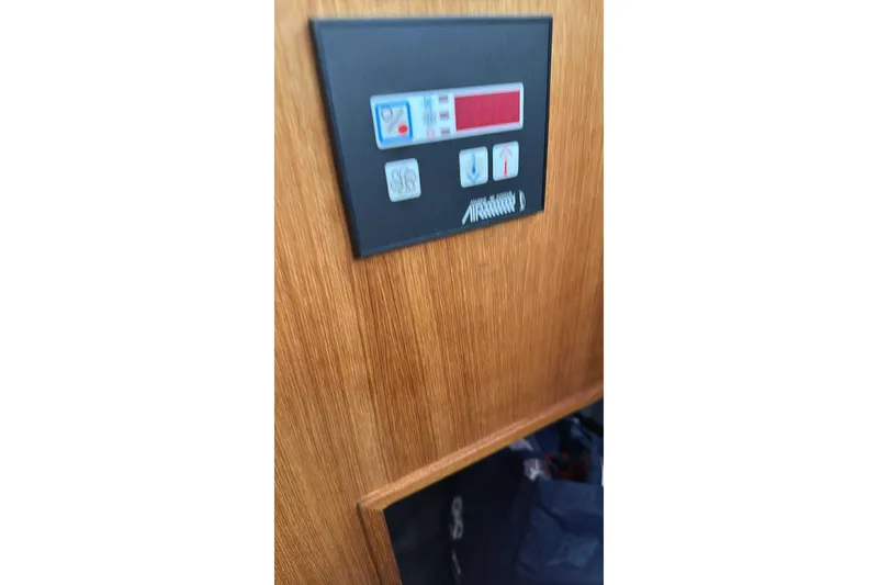 Slide: The Image of Control panel on 2014 Ranger Tugs R-27 boat, mounted on wooden surface. - 14