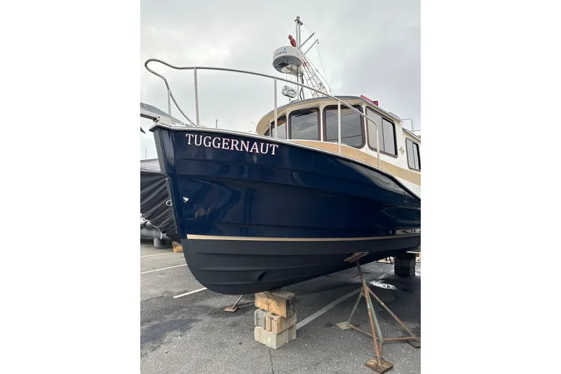 Slide: The Image of 2014 Ranger Tugs R-27 boat named "Tuggernaut" on dry dock, side view. - 4