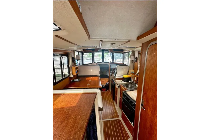 Slide: The Image of Interior of 2014 Ranger Tugs R-27 boat with wood finishes and compact kitchen area. - 7