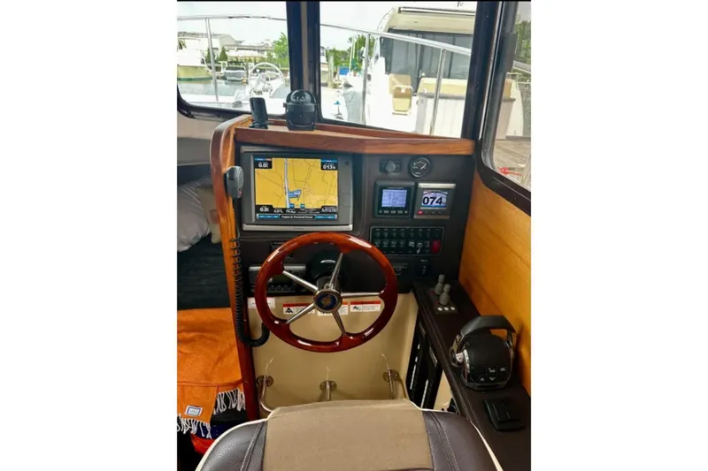 Slide: The Image of 2014 Ranger Tugs R-27 helm with navigation display and wooden steering wheel. - 9