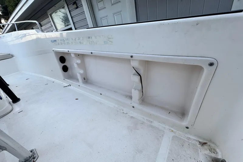 Slide: The Image of 2006 Century 2001 Center Console boat interior, featuring a white deck and storage compartment. - 14