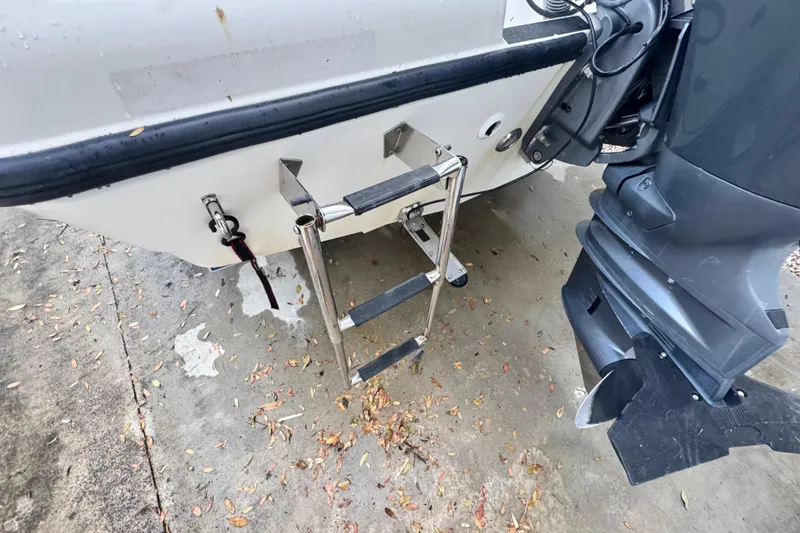 Slide: The Image of Century 2001 Center Console 2006 boat with ladder and motor on wet pavement. - 20