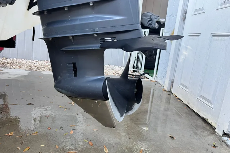 Slide: The Image of Outboard motor of a 2006 Century 2001 Center Console boat on wet pavement. - 23