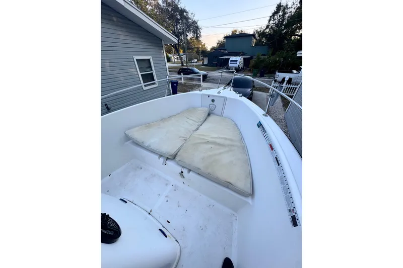 Slide: The Image of 2006 Century 2001 Center Console boat with cushioned seating, parked near a house. - 9