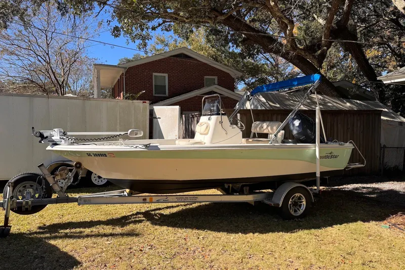 Slide: The Image of 2017 NauticStar 1810 NauticBay boat on trailer, parked in a residential yard. - 1