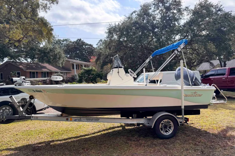 Slide: The Image of 2017 NauticStar 1810 NauticBay boat on trailer, parked in a residential area. - 4