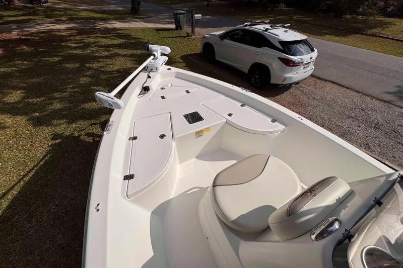 Slide: The Image of 2017 NauticStar 1810 NauticBay boat with white interior, parked near a white SUV. - 8