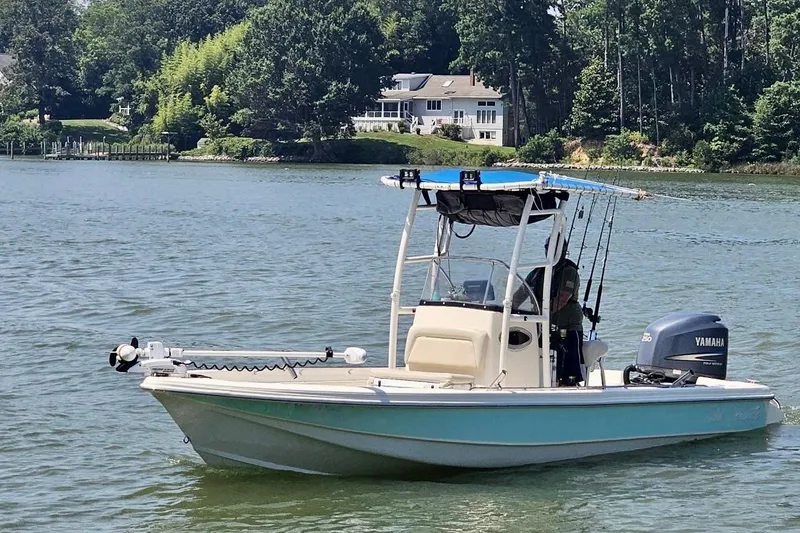 The Image of 2009 Scout 240 Bay Scout boat on a serene lake with lush greenery. - 0